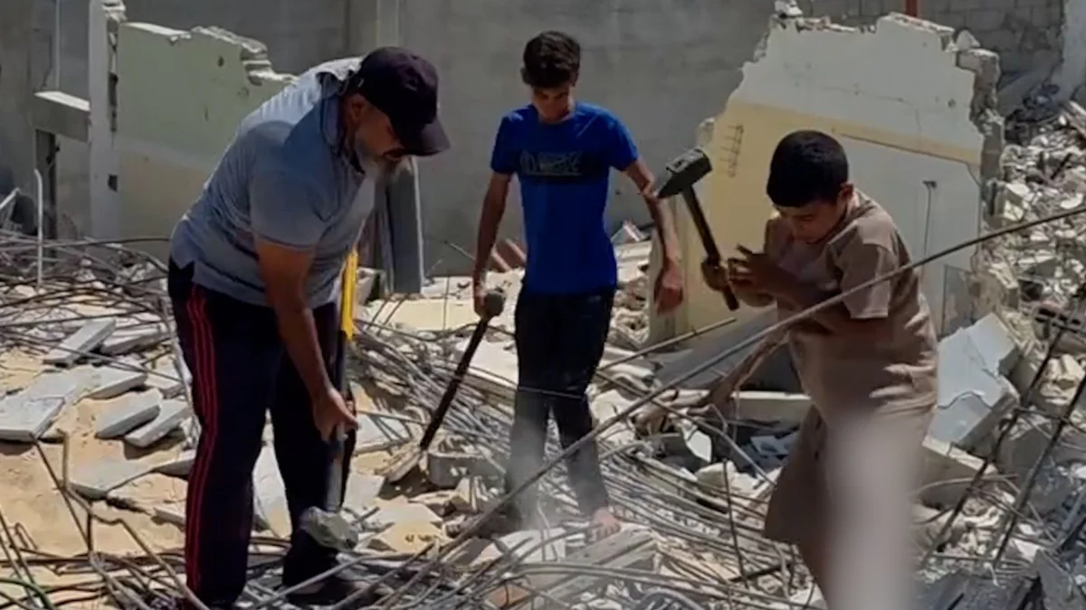 Father and sons manually clear rubble in Gaza